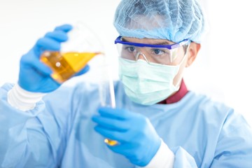 Asian scientists wear protective clothing while doing medical research in a science lab.  Concepts, laboratory research on the antiviral drug Covid 19