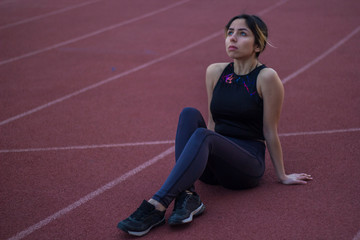 woman tired of doing sports, sitting on the track