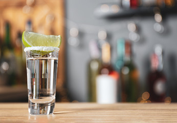 Mexican Tequila with salt and lime slice on bar counter. Space for text