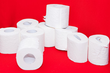 Toilet paper rolls on a red background . The lack of toilet paper. Rolls of white paper.