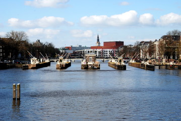 View over the Amstel river on the Amstel locks with the Opera building and tower of the Zuiderkerk in the background in the center of Amsterdam
