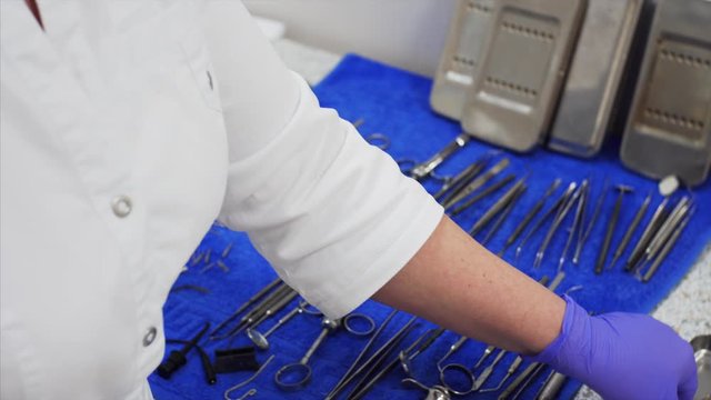 Nurse is wiping dental instruments after sterilization and washing. Dental clinic