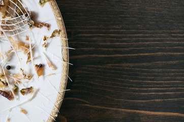 Fish bones on a single white plate. Wooden table background with copy space