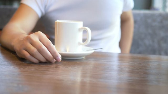 closeup. the man wears a wedding ring, sitting in a cafe.