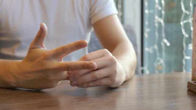 closeup. the man wears a wedding ring, sitting in a cafe.