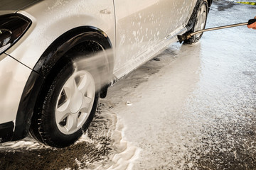 Washing wheel arch with a jet of water. High pressure car wash.