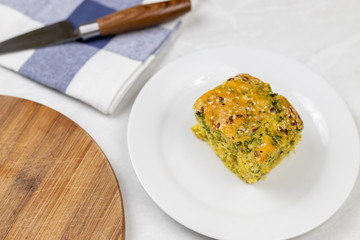 Cornbread with spinach on the plate with kitchen utensils