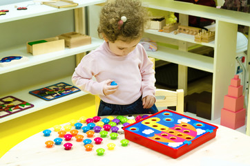 little girl collects a puzzle. study of colors. child development. game at home
