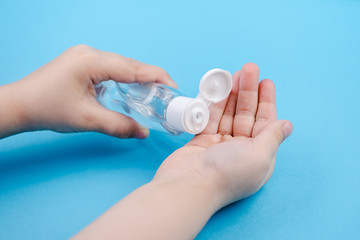 Hand cleaning gel. Pouring sanitising hand gel onto the child's hand