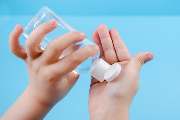 Hand cleaning gel. Pouring sanitising hand gel onto the child's hand
