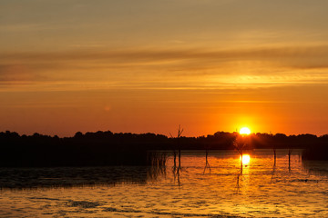Fototapeta na wymiar Beautiful sunset with orange clouds at the lake
