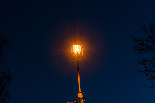 A street light at dusk. Sodium-vapor street lamp.