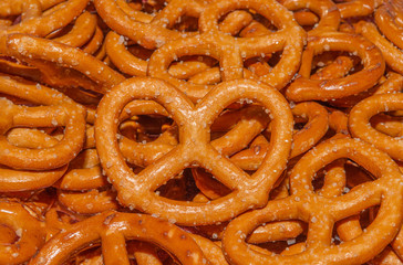 Salted Bavarian pretzel close-up, beer snack. Mini pretzel, fresh baked goods. Background or texture of fresh baked pastry. Background of pretzels.	