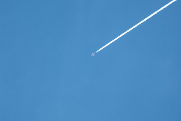 Airplane Flying with White Vapor Trails or Chemical Trails Conspiracy Theory