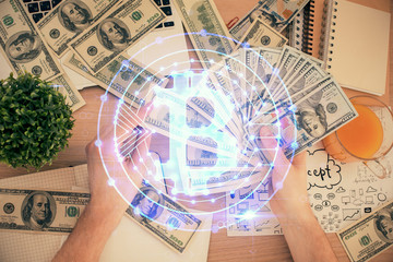 Multi exposure of blockchain theme drawing hologram and USA dollars bills and man hands. Business concept.