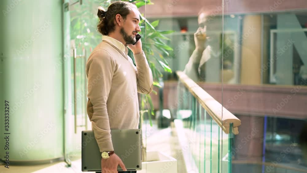 Poster caucasian marketer in smart casual clothing using smartphone application for calling and talking abo