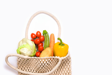 Organic vegetable. Potato, Zucchini, Carrot, Bell Pepper; Tomato;  Salad in eco wicker bag isolated on white background. Healthy eating concept, environmental awareness, ecological template