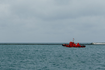 red tug ship sailing by the sea at Odessa seaport