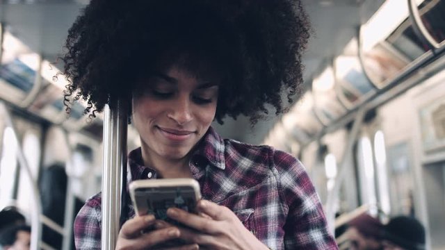Afro American female on subway with smart phone