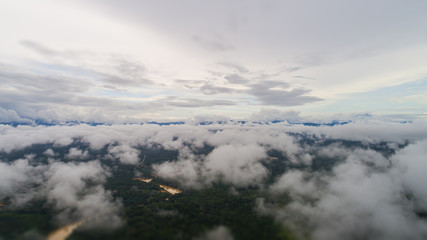 Fototapeta na wymiar Over the clouds at the Malaysian landscape. Aerial view over the rainforest near the Gua Charas Rock, Pahang, Malaysia, not far from the east coast of Malaysia and the town of Kuantan. 