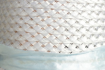 The patterned surface of the light blue fabric is placed outdoors.