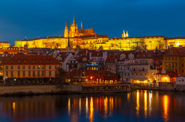 Fototapeta na wymiar Prague Castle, also known as Hradcany Castle, at night along the Vltava river and the Saint Vitus cathedral on top, Czech Republic.