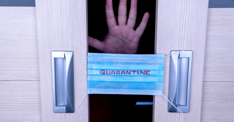 Medical face mask against infection with coronavirus on the door handle to a quarantine room