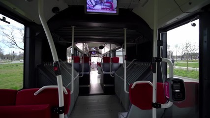 Interior of new modern empty bus with screens and red seats. Rows of empty seats in public transport for corona quarantine, European covid crisis - Powered by Adobe