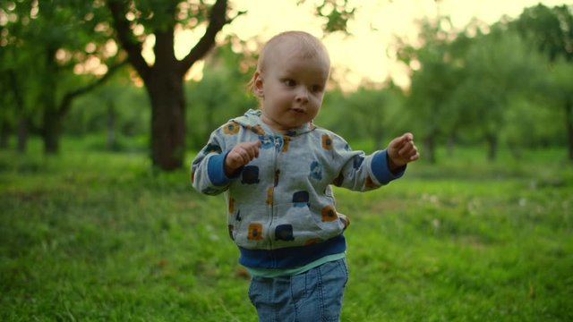 Little Baby Walking In Green Forest. Close Up Of Adorable Toddler Outdoors