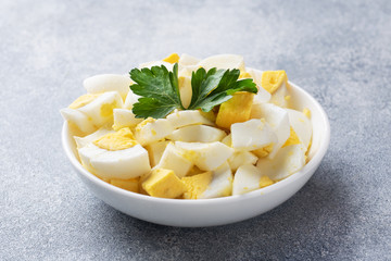 Chopped boiled chicken egg in a plate with parsley. Copy space