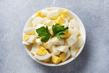 Chopped boiled chicken egg in a plate with parsley. Copy space