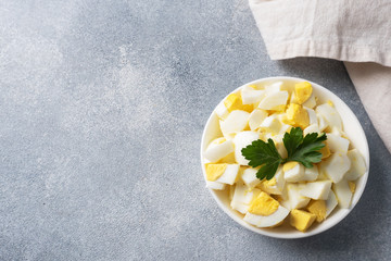Chopped boiled chicken egg in a plate with parsley. Copy space