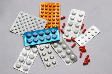 Set with various pills on white cardboard. Medical facilities. A pile of pills in blister packs. Close-up on a light background. Pharmaceutical blister pack.