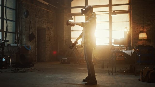 Talented Female Artist Wearing Virtual Reality Headset and Holding Digital Joysticks. She's Working on a Painting or Sculpture, Uses Motion Controllers To Create Concept Art. Creative Modern Studio.