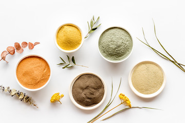 Blue, yellow, white. red, black cosmetic clay background on white table top-down