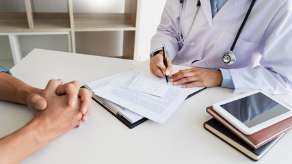 patient listening intently to a male doctor explaining patient symptoms or asking a question as...