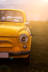 Obraz na płótnie Canvas Vintage retro yellow car in the morning sun.