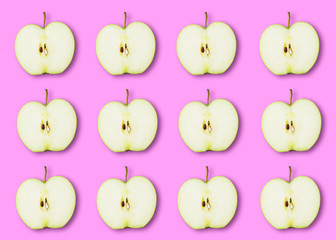 Slices of ripe green Apple on a pink background. Pattern Wallpaper Flat lay top view.
