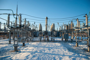High voltage transformer substation in winter. High voltage power lines. Power transmission...