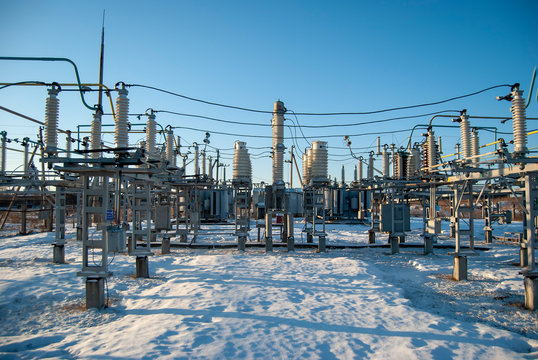 High voltage transformer substation in winter. High voltage power lines. Power transmission technology.