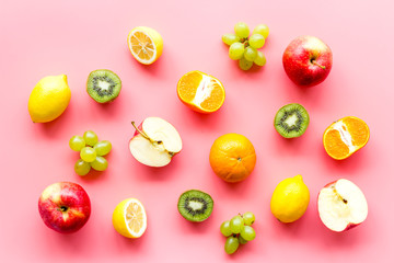 Colorful fruit pattern. Cut apple, kiwi, citrus on pink background top-down