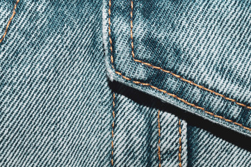 Jeans background with seams. denim texture close up. fabric backdrop