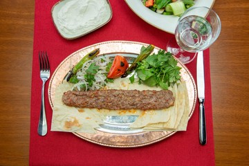 Traditional oriental Adana kebap and shashlik skewer with tomato and flatbread stock photo