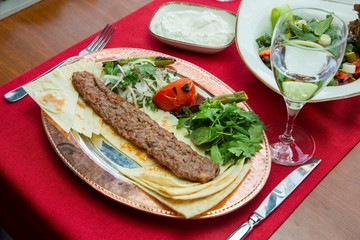 Traditional oriental Adana kebap and shashlik skewer with tomato and flatbread stock photo