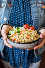 Vegetable bulgur pilaf or pulao. Woman holds in hands turkish  or Levantine Arabic durum wheat cooked grain as part of vegan, vegetarian healthy  diet food.