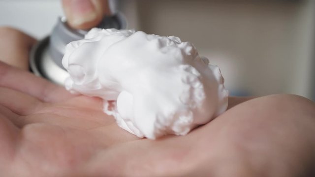 Shaving foam is squeezed out of bottle onto female hand. Shaving armpits legs back chest mustache beard concepts. Close-up
