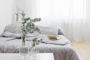 eucalyptus in glass vase in white bedroom