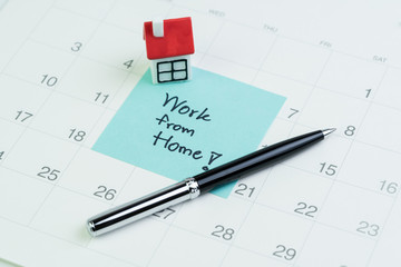 Work from home social distancing in COVID-19 Coronavirus pandemic concept, miniature house on sticky note written the word Work from home on calendar