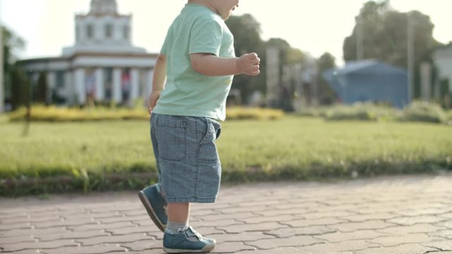 Unrecognized boy running in amusement park. Little kid walking rapidly outdoors
