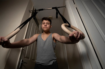 Boy exercise on the gymnastic  rings in home